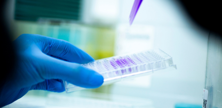 "Researcher Researcher dropping liquid from a dropper into small containers